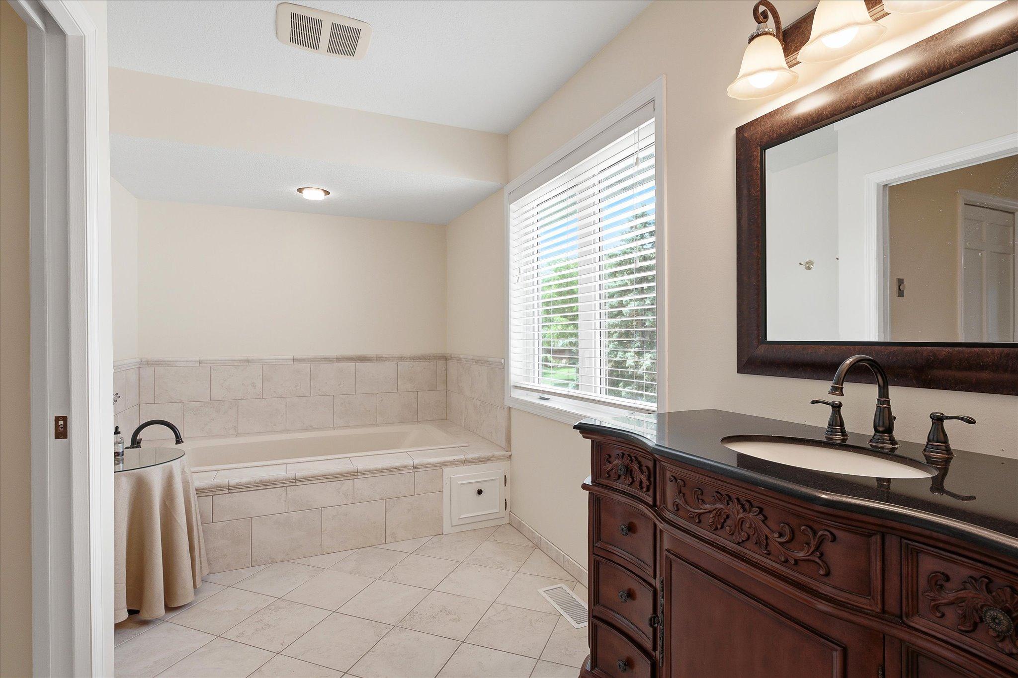 Vanity and jetted tub in main bath.