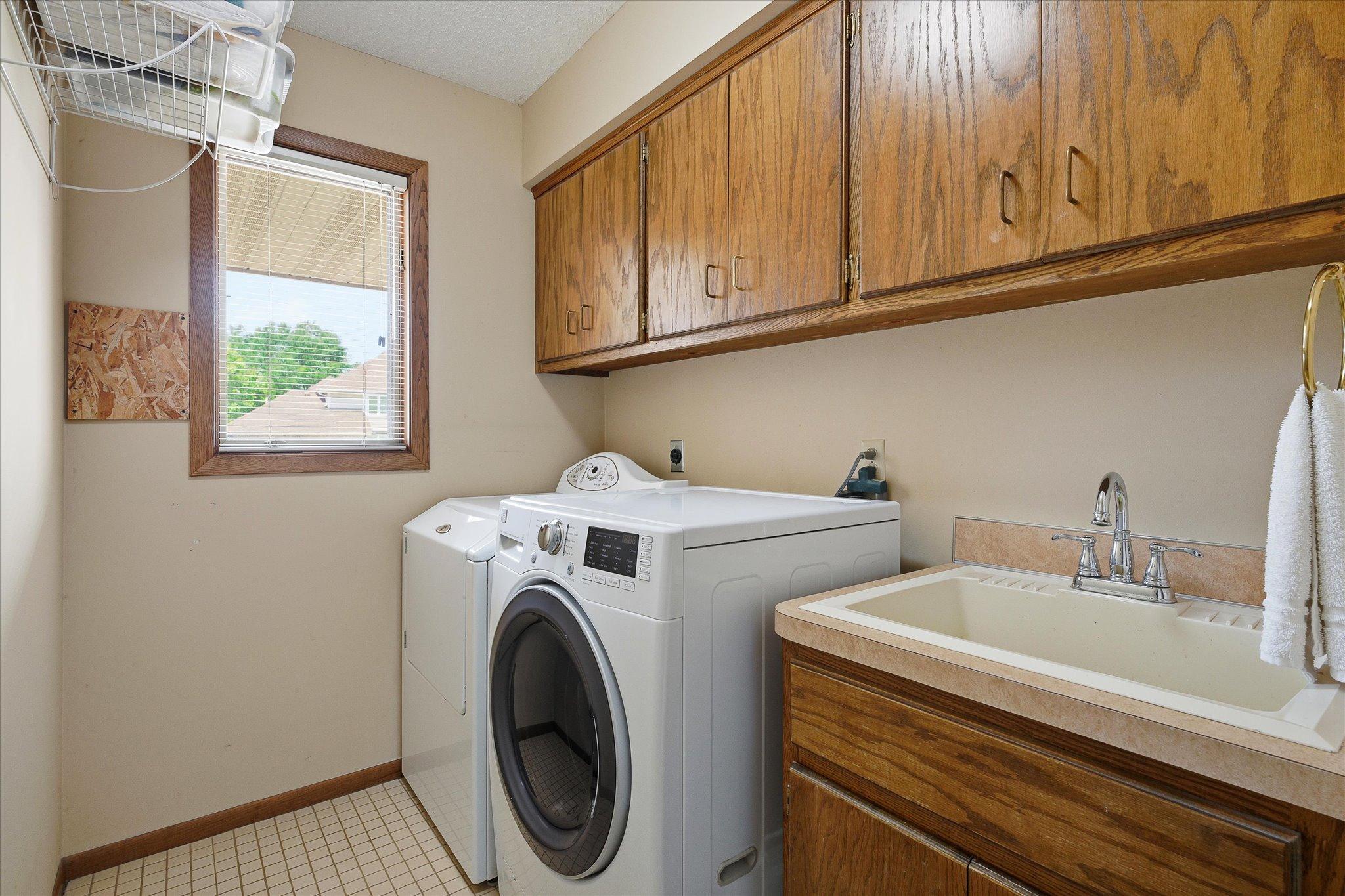 Main floor laundry with laundry sink and extra storage.