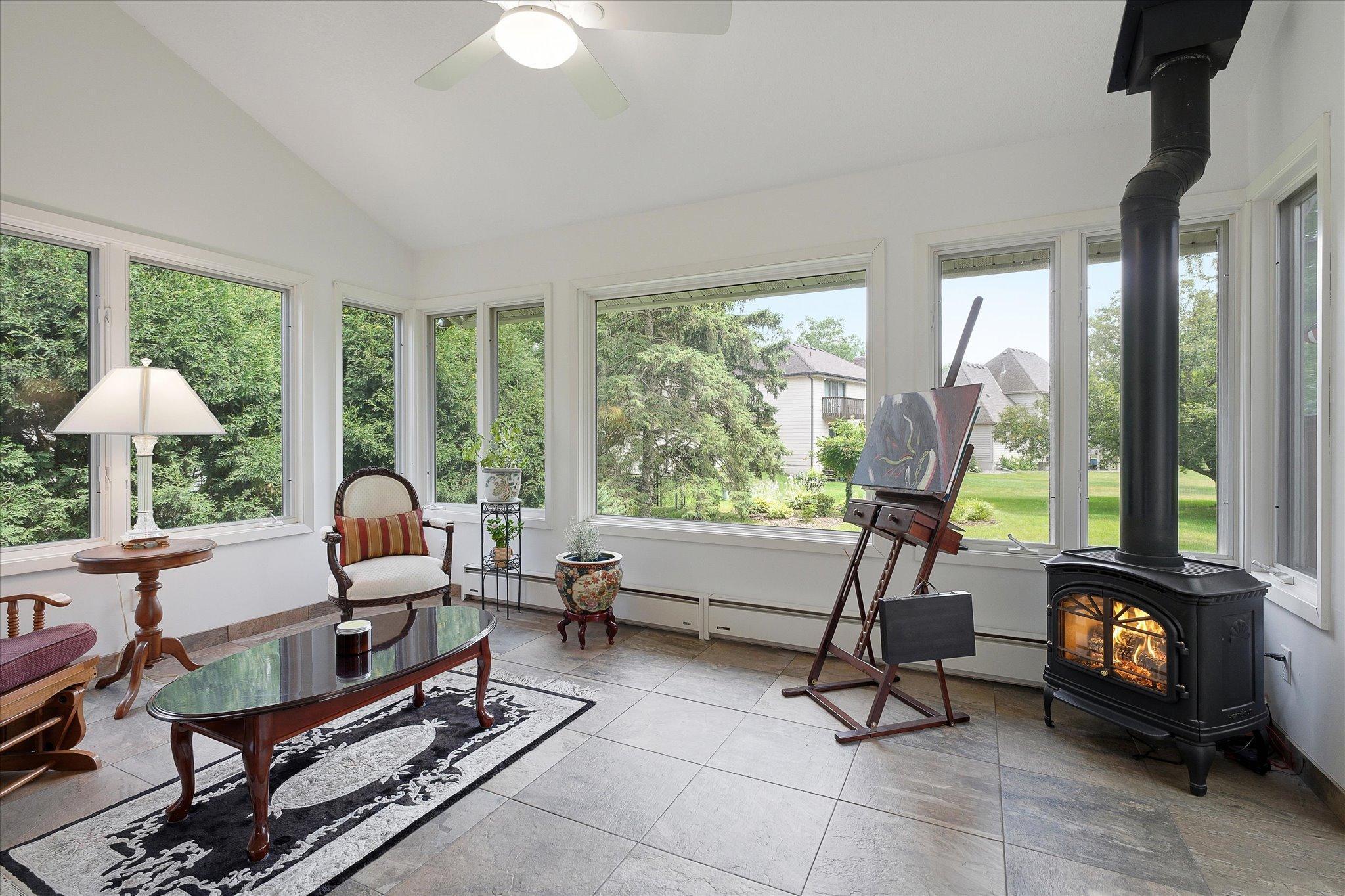 Freestanding wood stove gives a cozy feel to the sunroom on cold days.