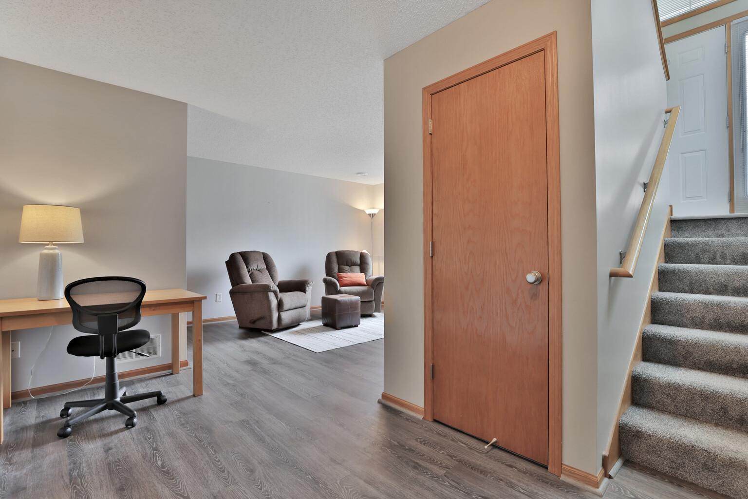 Basement area as you enter from the attached garage. Stair case to main level kitchen and dining/living room area.