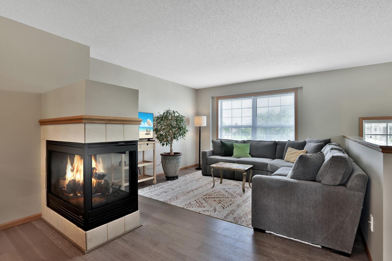 Open concept main level with 3-sided fireplace and an abundance of natural light.