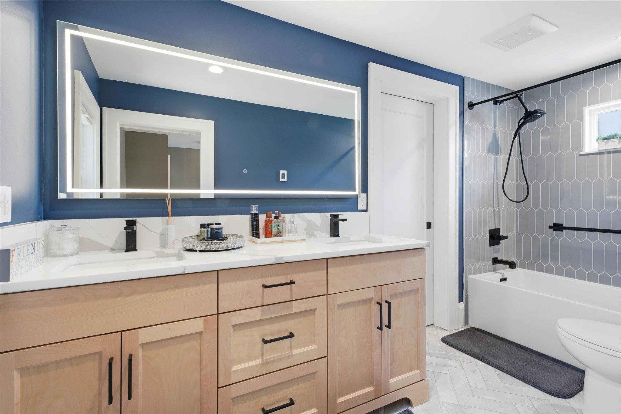Dual sinks, tiled & heated floor, touch light mirror in the primary suite
