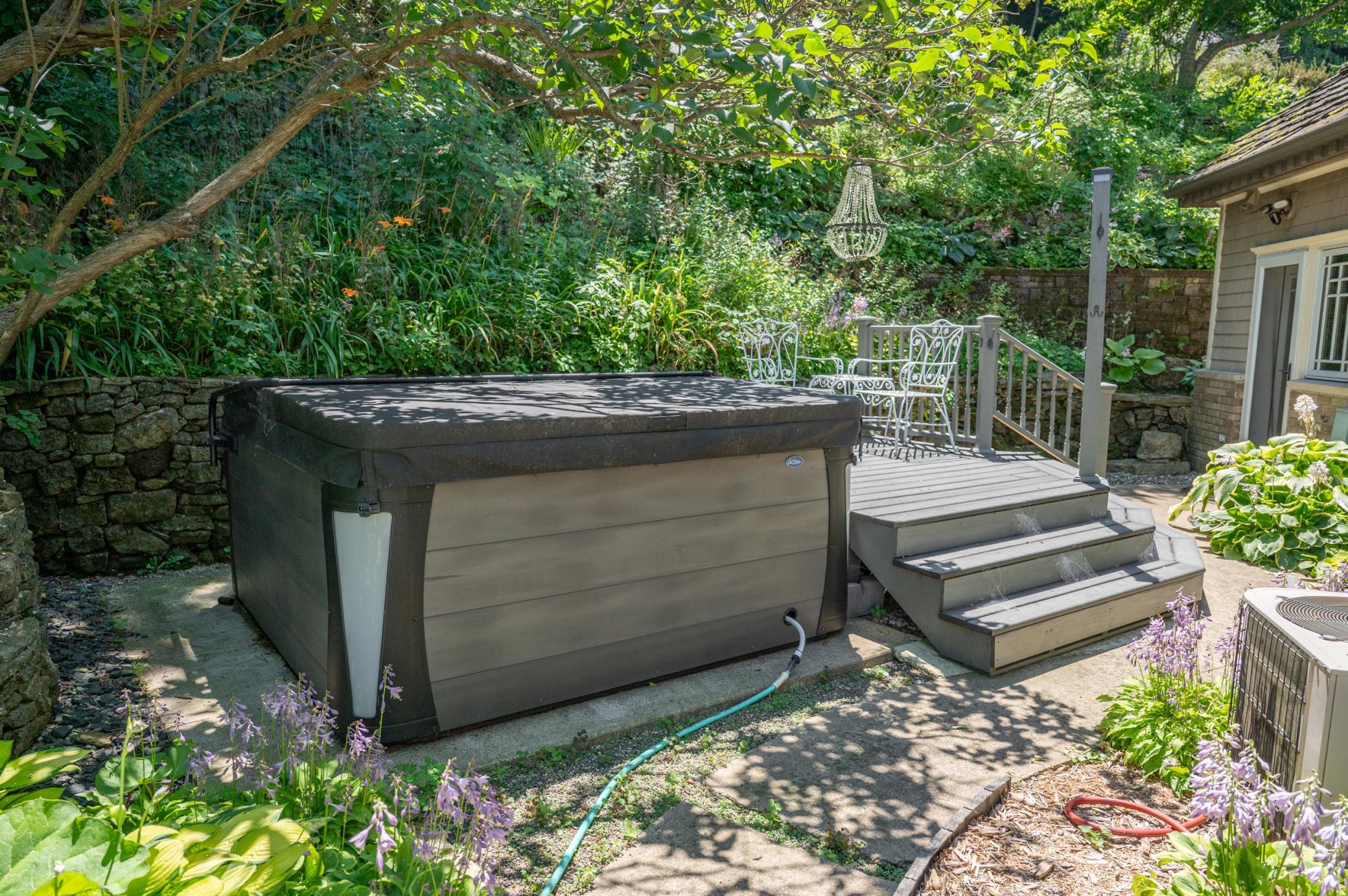 Sitting on a secluded side of the home a small deck and hot tub are perfect for relaxing and unwinding after a busy day.