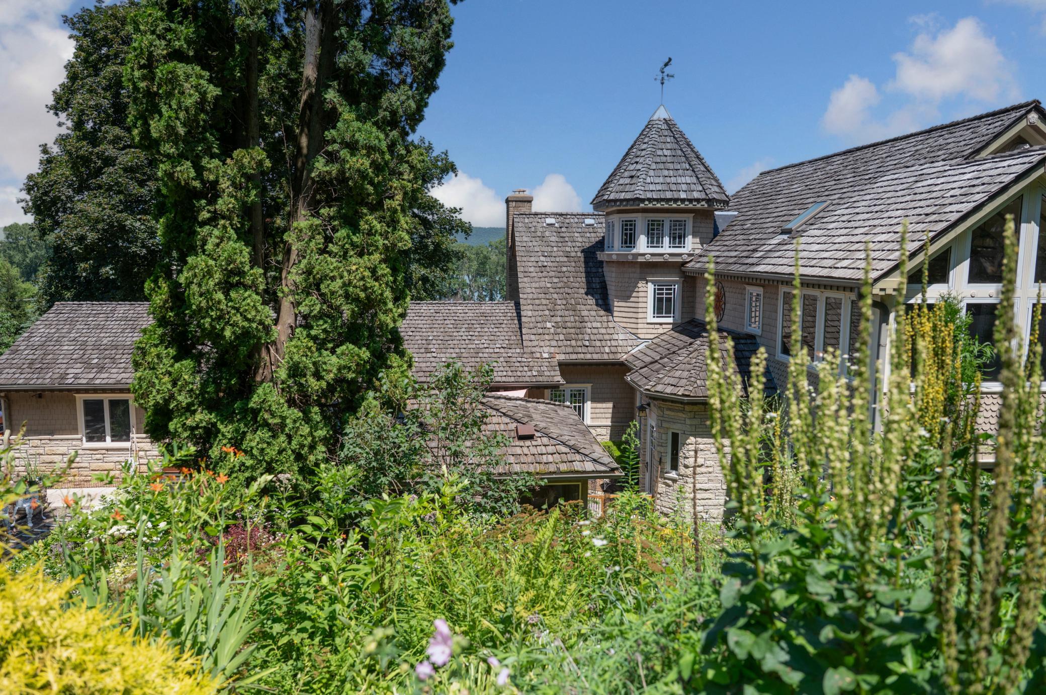 A cedar shingle roof and dynamic rooflines make this a memorable home. The flower boxes at the base of the turret windows feature a water line to water flowers remotely from.