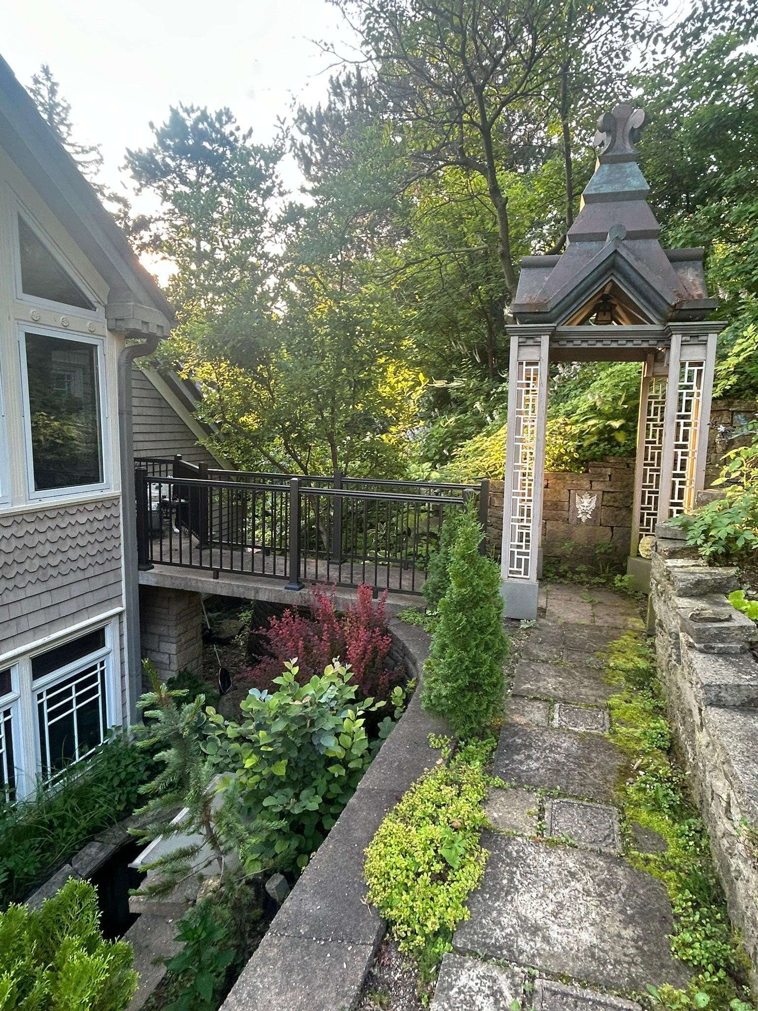 An ornate pergola adds a striking visual feature just outside the back of this home and can be easily reached by the bridge from an equally stunning room on the second level.