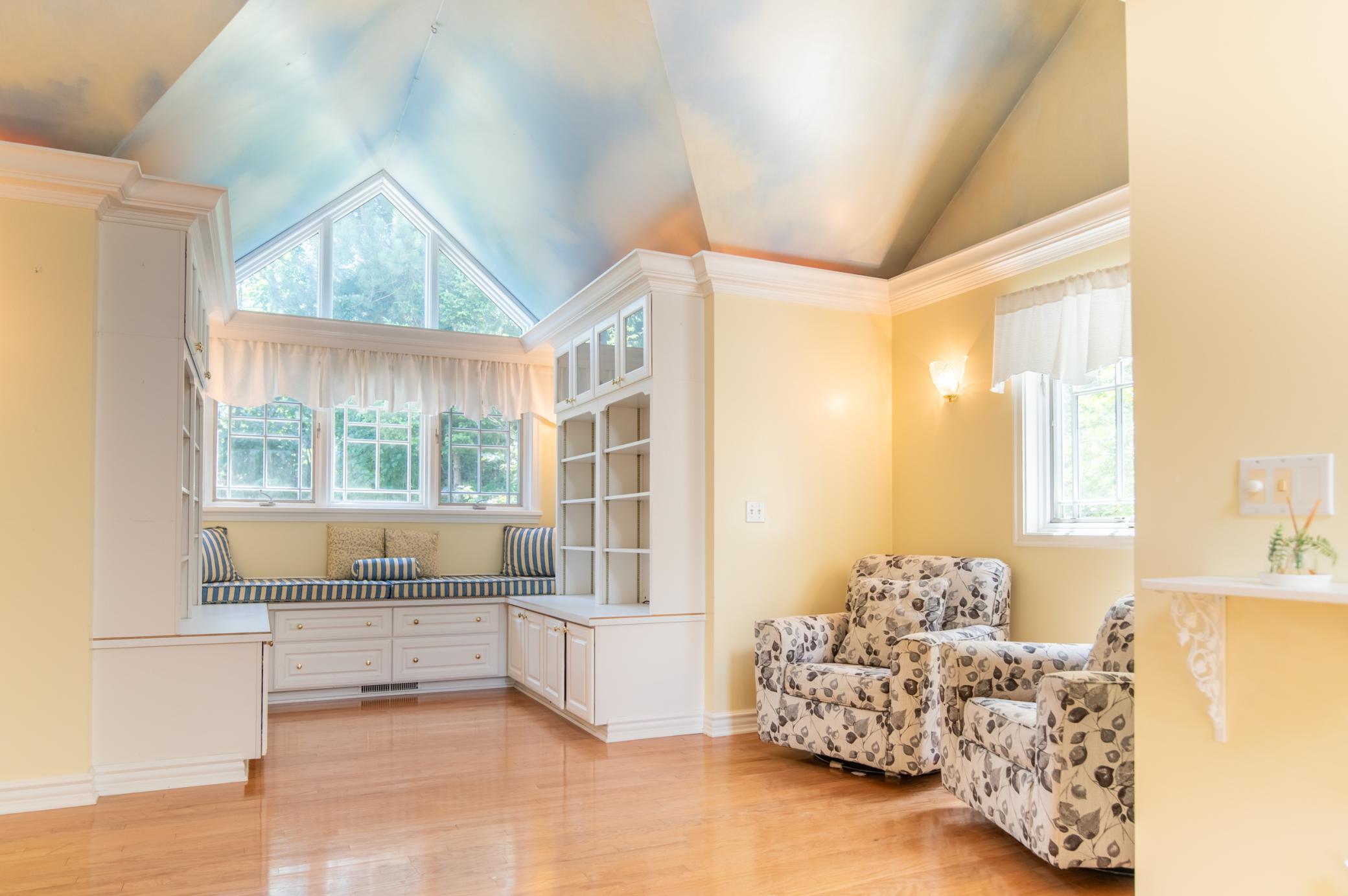 Cloud and sky elements plus a the warm walls give this room a sunny inviting feel. This space could be a luxurious master suite, nursery, or a great play room.