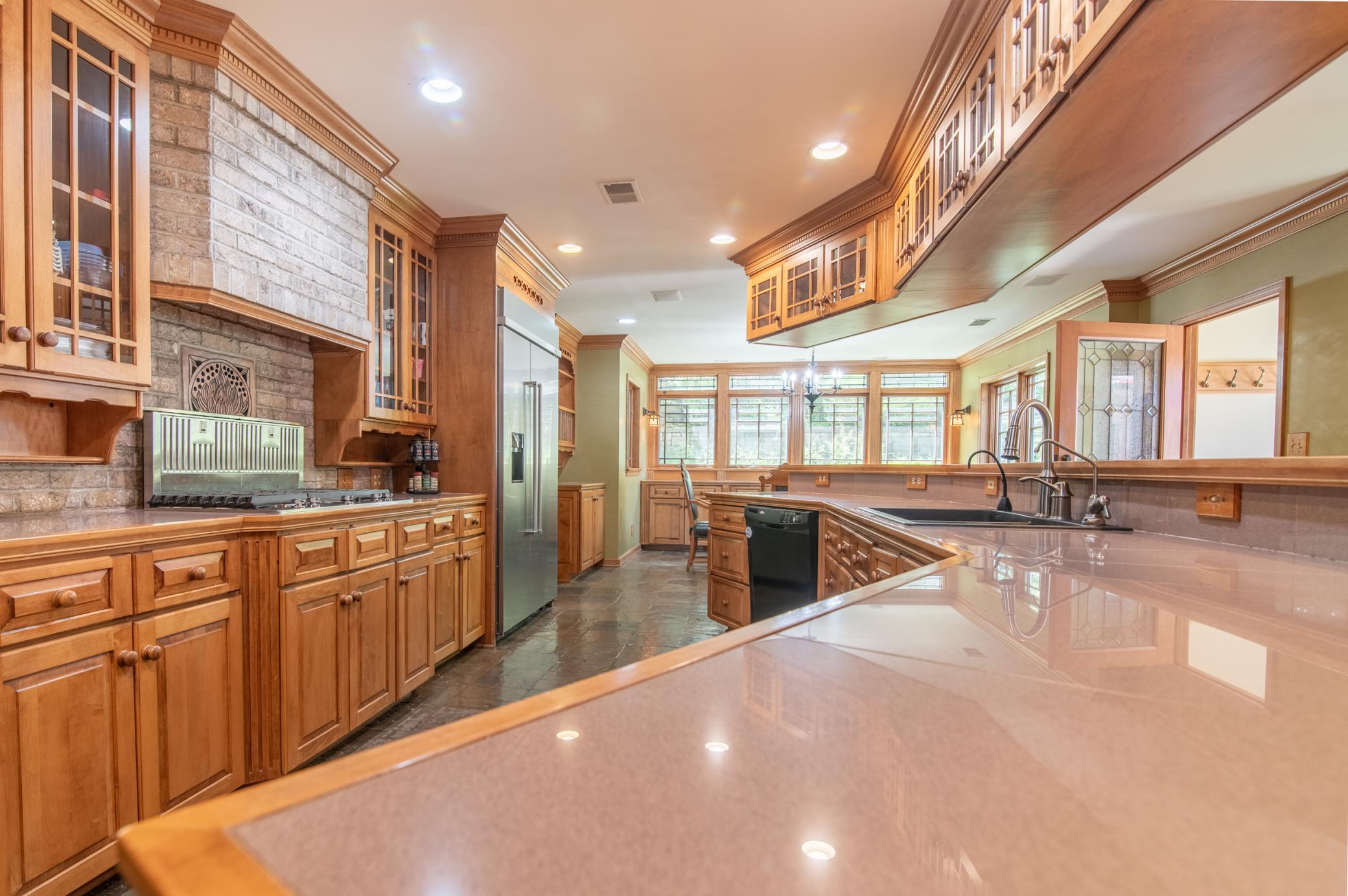A retractable vent fan on the stove and striking maple cabinets make for a stunning kitchen.