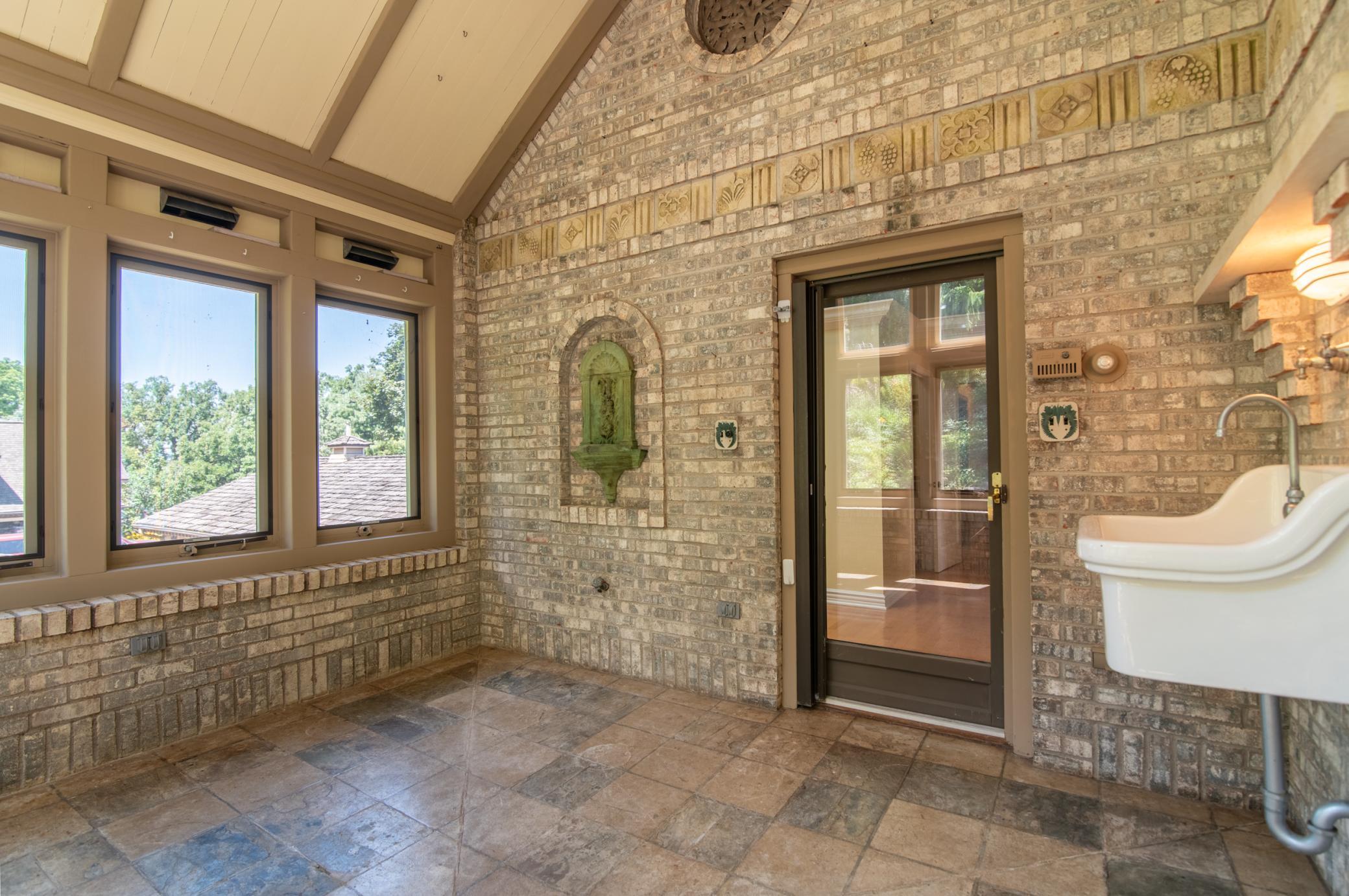 At the back of the home, this space was used as a greenhouse for past owners but would also make a great room to absorb the warmth of a sunny day. The sink at right comes from the Winona hospital where one previous owner was a doctor.