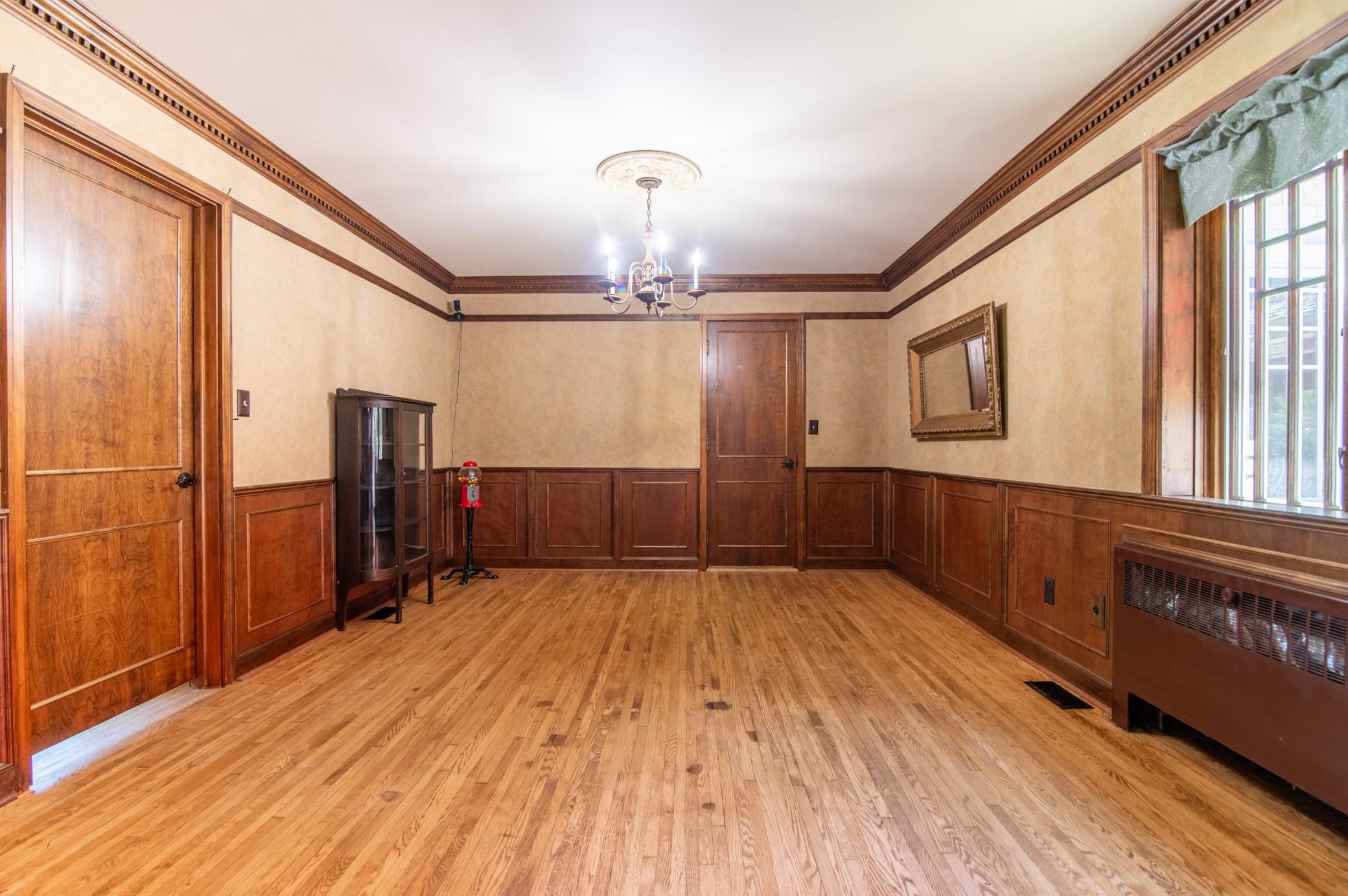Natural woodwork abounds in the dining room. To the left, the door seen leads to the front living room/den. The door at back of frame leads directly to the kitchen.