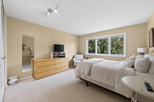 Large bright and cheery bedroom, boasting a bank of newer windows, complimented by black out shades.