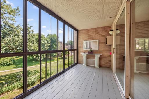 Large 15 x 7 Screened porch offers views of Minnehaha Creek, and wooded areas. Wood plank flooring and brick walls compliment the space.