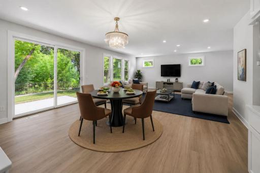 The open-concept living room and informal dining area are bright and airy, featuring oversized windows and a sliding glass door that fills the space with natural light and provides seamless access to the expansive patio. Virtually Staged.
