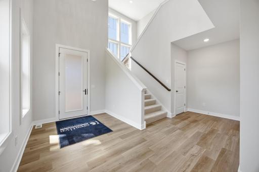 Unfurnished view of the impressive two-story foyer, featuring soaring ceilings and expansive windows.