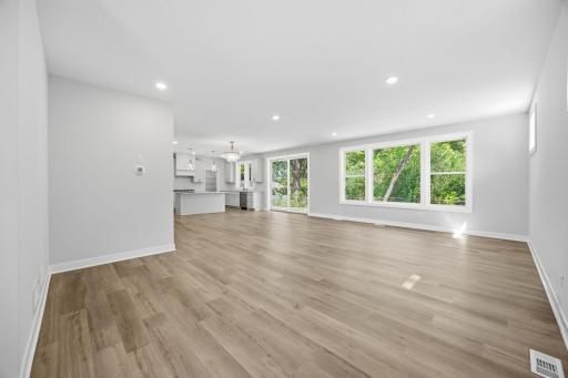 This view from the foyer highlights the home's open layout, connecting the living room, informal dining area, and kitchen.