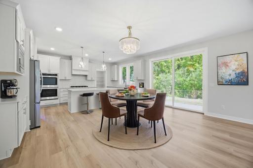 The kitchen/informal dining room area, features quartz countertops, a center island with a breakfast bar, a porcelain tile backsplash, SS appliances, and an extraordinary 15' x 6' walk-in pantry, offering exceptional storage and functionality.