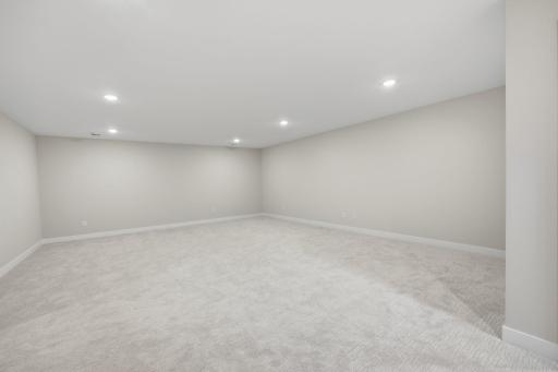 Unfurnished lower-level family room offering abundant space for recreation, relaxation, and entertaining.