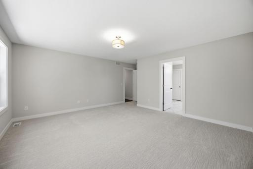 Unfurnished primary bedroom with direct access to the luxurious primary bath, creating a private and relaxing retreat.