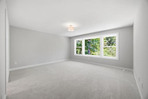 Unfurnished owner's suite showcasing a luxurious private bath with a soaking tub, walk-in shower, dual vanities, and a large walk-in dressing room.