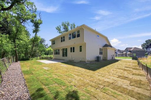 Backyard featuring brand-new landscaping, fresh sod, and a new stone patio, all completed in July 2026.