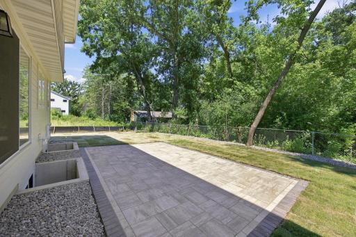 Close-up view of the new stone patio completed in July 2026. The exterior stairs connecting the house to the patio will be installed by the builder prior to closing.