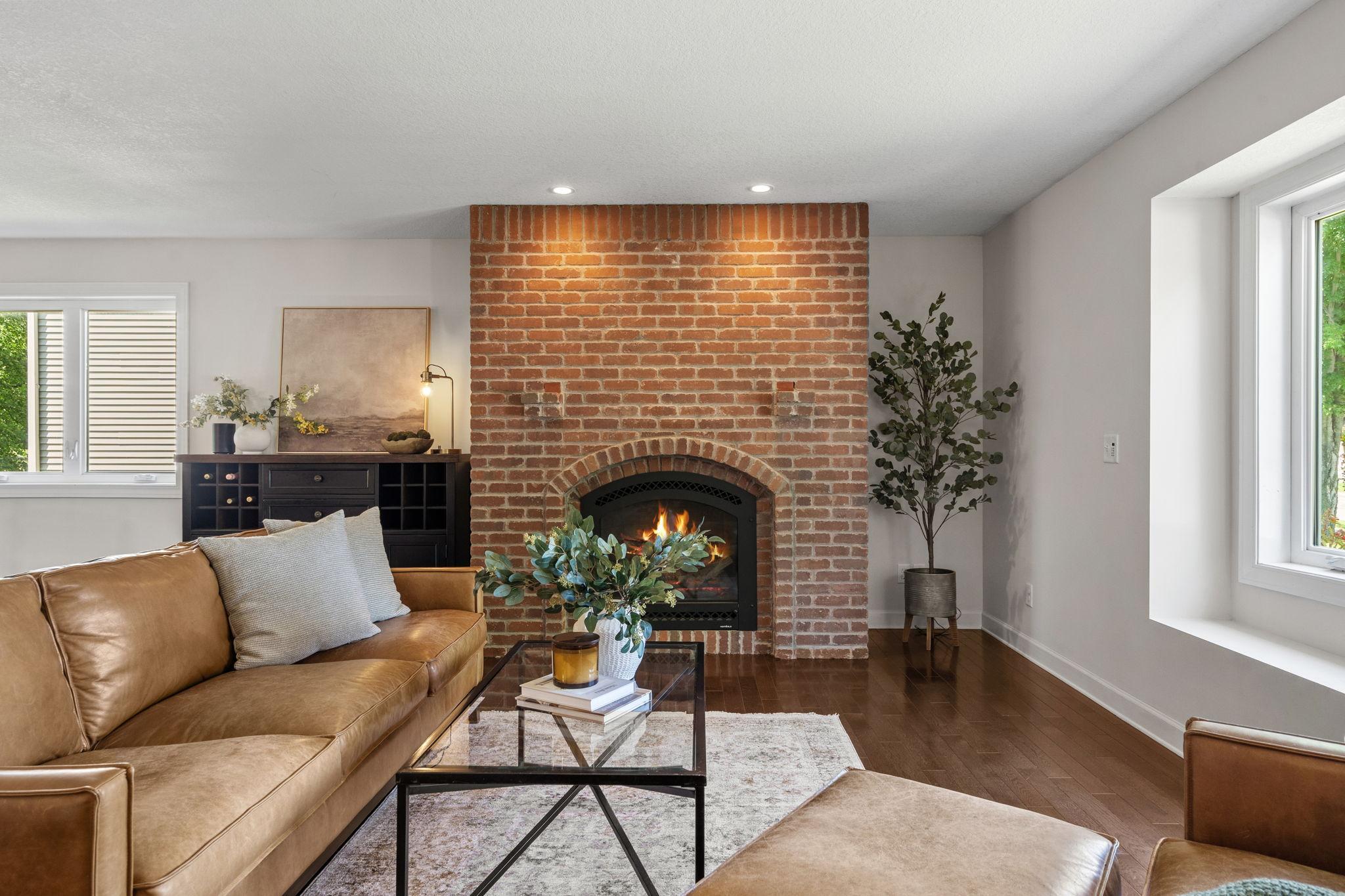 Floor-to-ceiling brick fireplace creates a warm focal point.