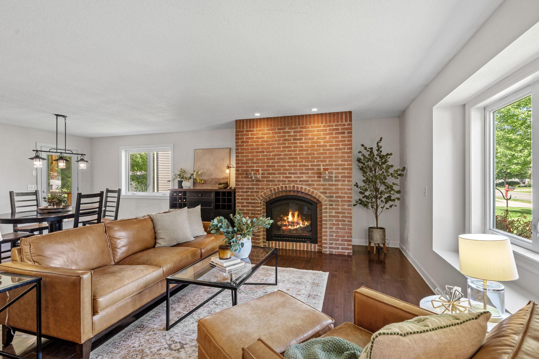 Spacious living room anchored by a stunning brick fireplace.