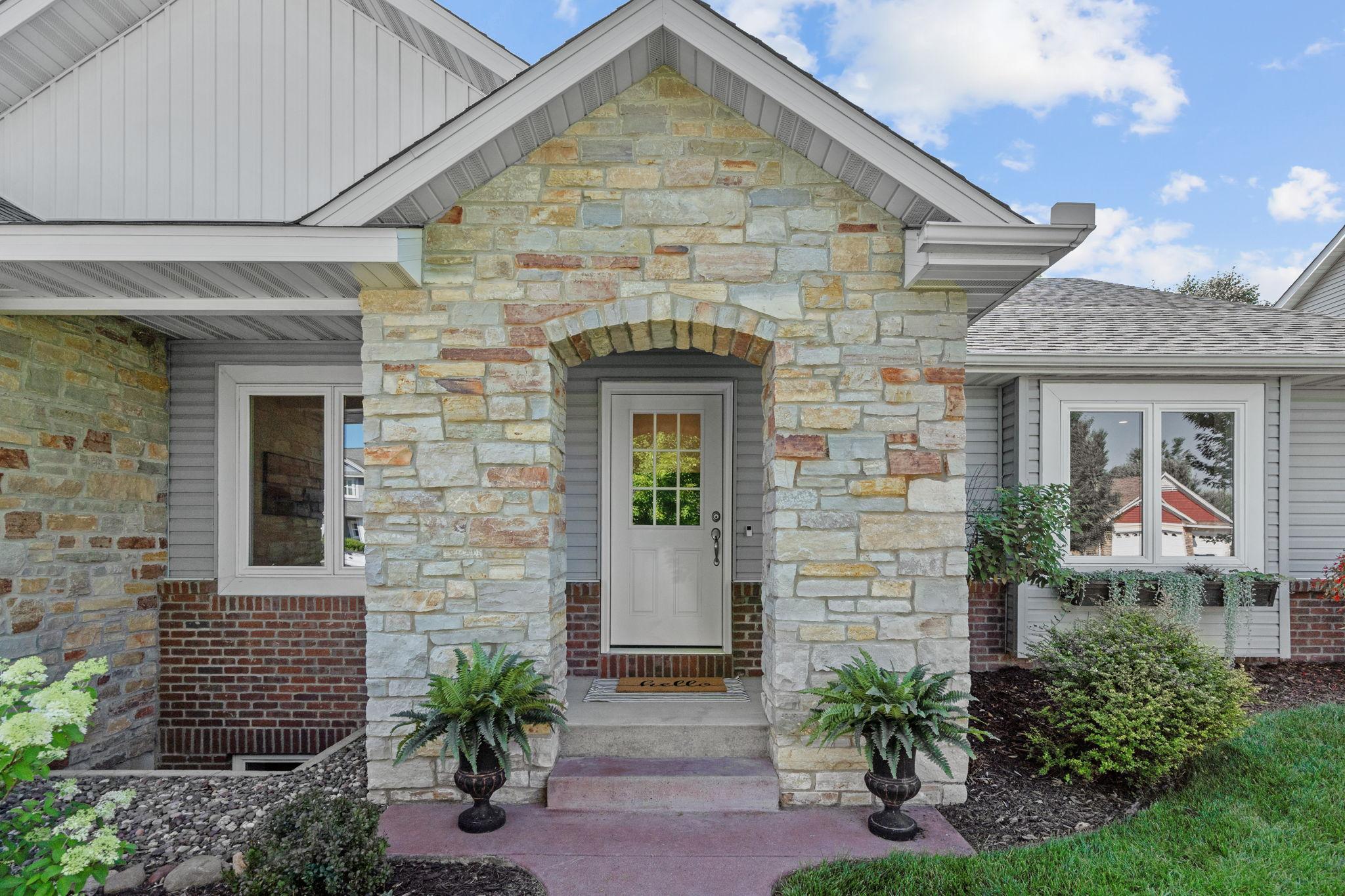 Inviting front entrance with timeless stone and brick accents.