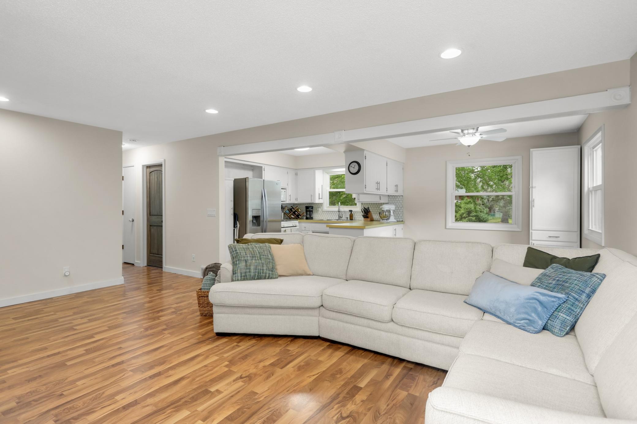 Living room is open to kitchen and dining with vinyl flooring flowing throughout