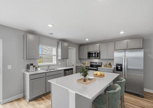 The Edison floor plan offers a spacious kitchen with island for seating, stainless steel appliances, and a large walk-in pantry! Model photo. Options and colors will vary.