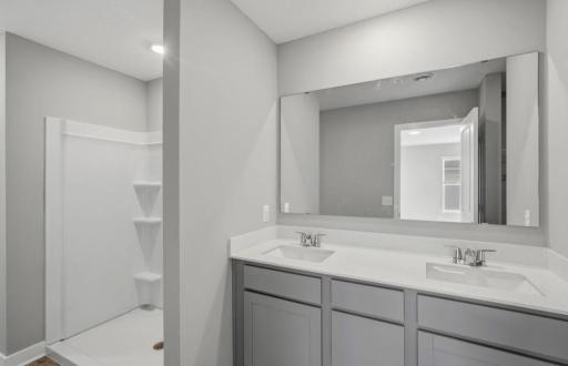 Primary suite including private bath with dual sinks and walk-in closet. Model photos. Options and colors will vary.