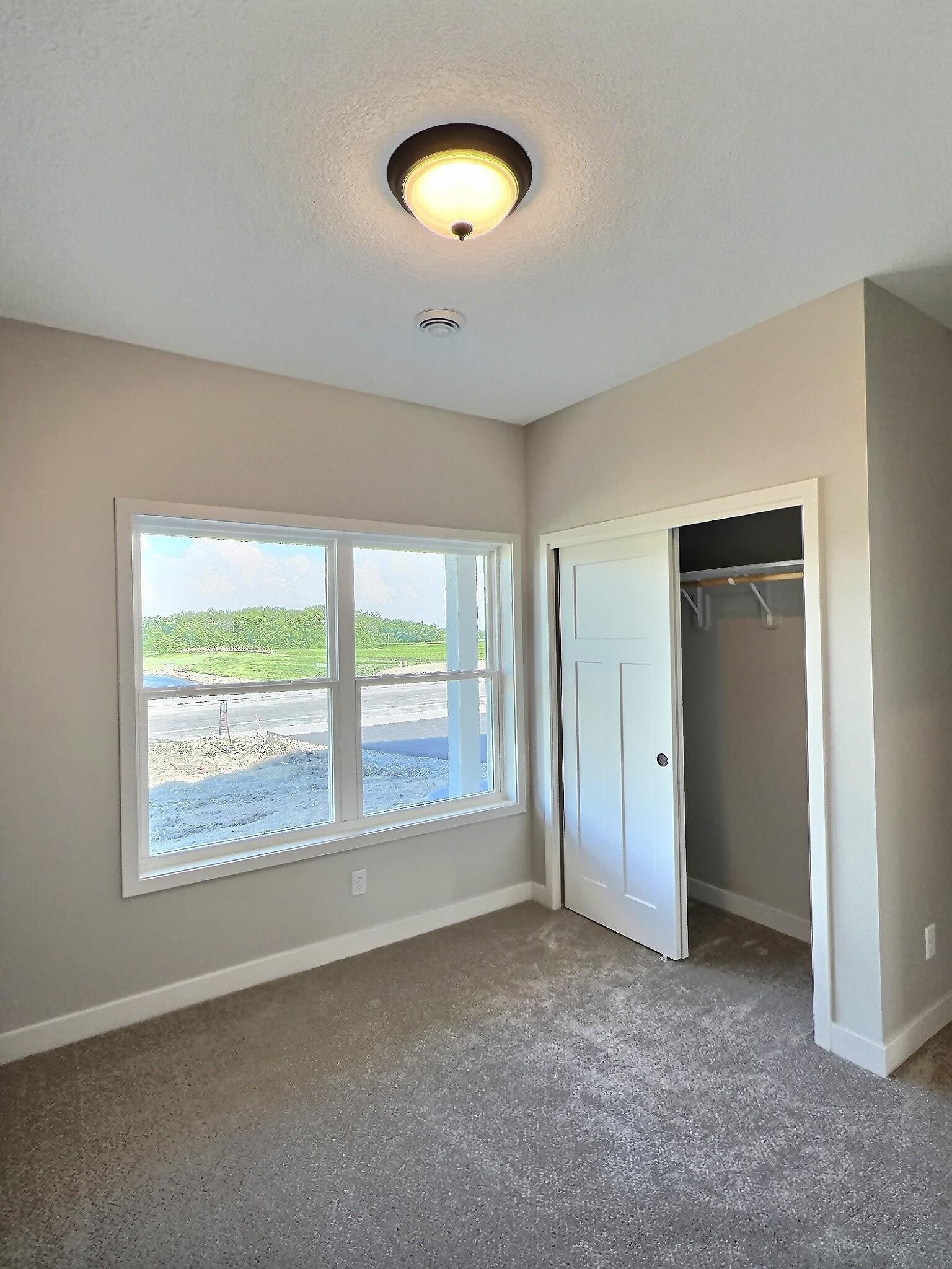 The first bedroom is located at the front of the home, overlooking the front porch and yard, making it an ideal space for a home office. Photo is of current model that is sold.