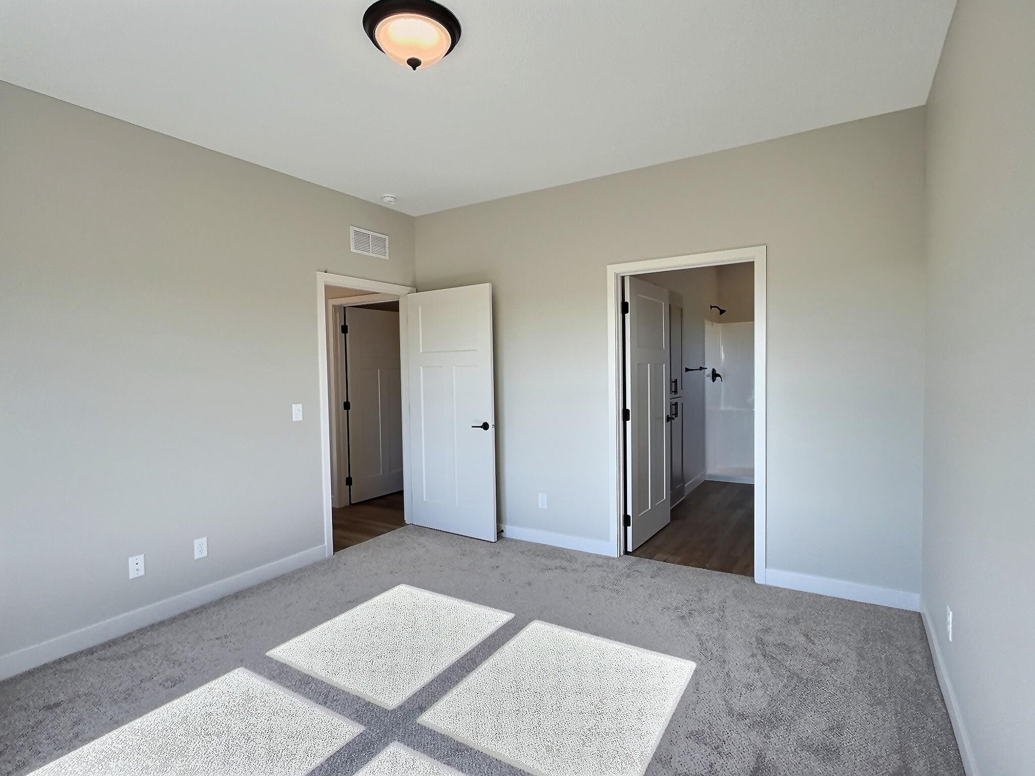 2nd photo of the primary showing the door the private bath. Photo is of current model that is sold.