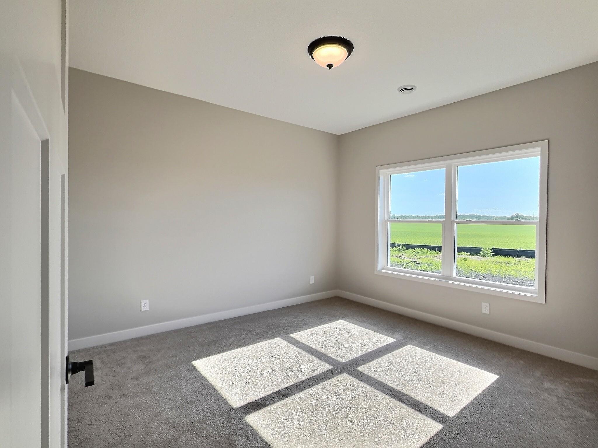 The primary bedroom offers private bath with walk in shower and walk in closet with the laundry room conveniently located right outside the door. Photo is of current model that is sold.