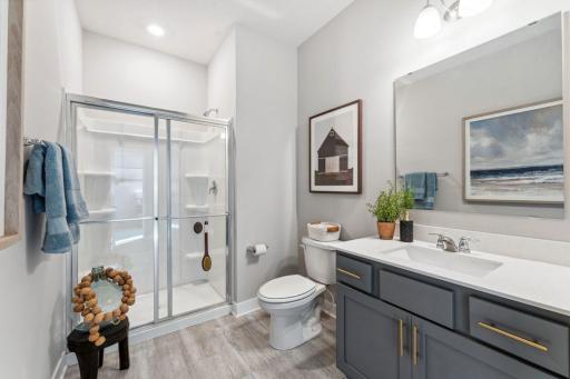 You'll find two baths on the main floor. This 3/4 bath is adjacent to the 5th bedroom. What a perfect suite for visitors! Photo of model home, colors and finishes are similar.