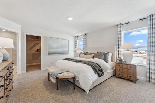 Your spacious primary suite has a private bath and separate oversized walk in closet. Photo of model home, colors and finishes are similar.