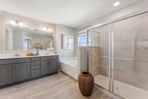 Walk in shower, soaking tub, dual sinks, and private water closet complete the primary bathroom. Photo of model home, colors and finishes are similar.