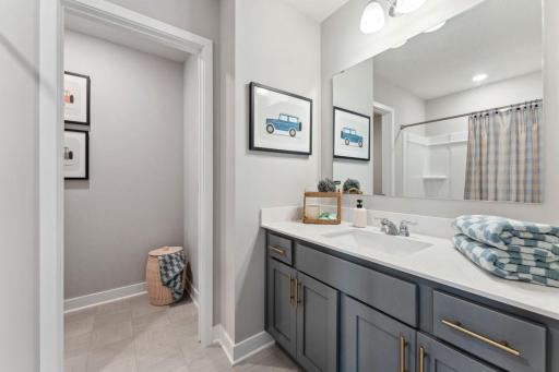 Across the hall from the two secondary bedrooms, this full bath has a separate water closet. Photo of model home, colors and finishes are similar.