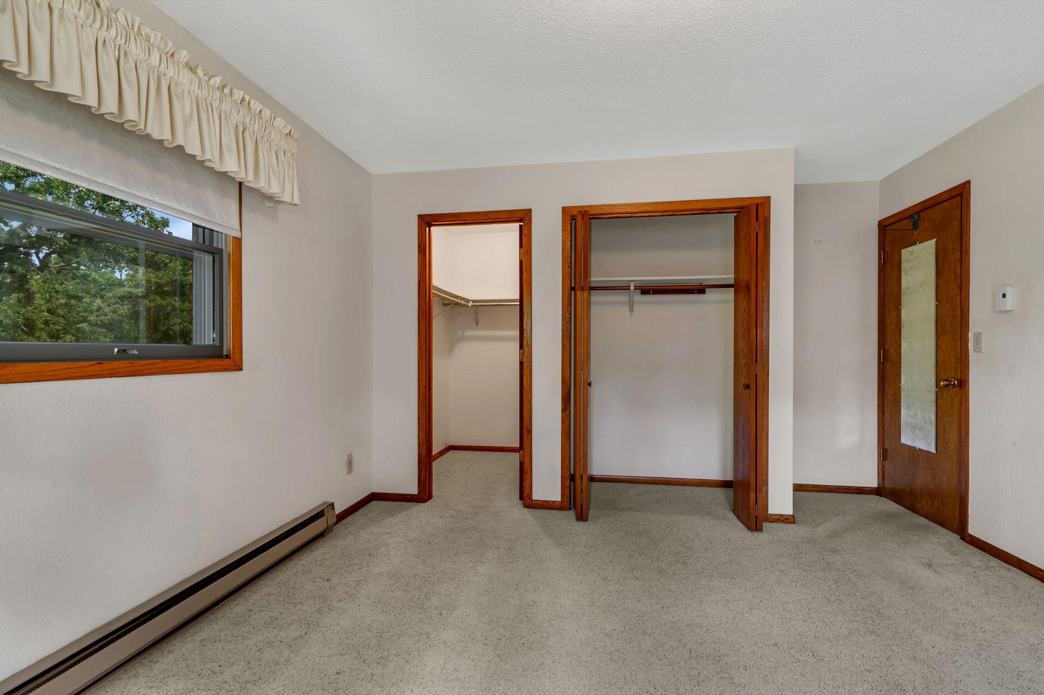 First of two bedrooms on the main level offers a backyard view - Dual closets