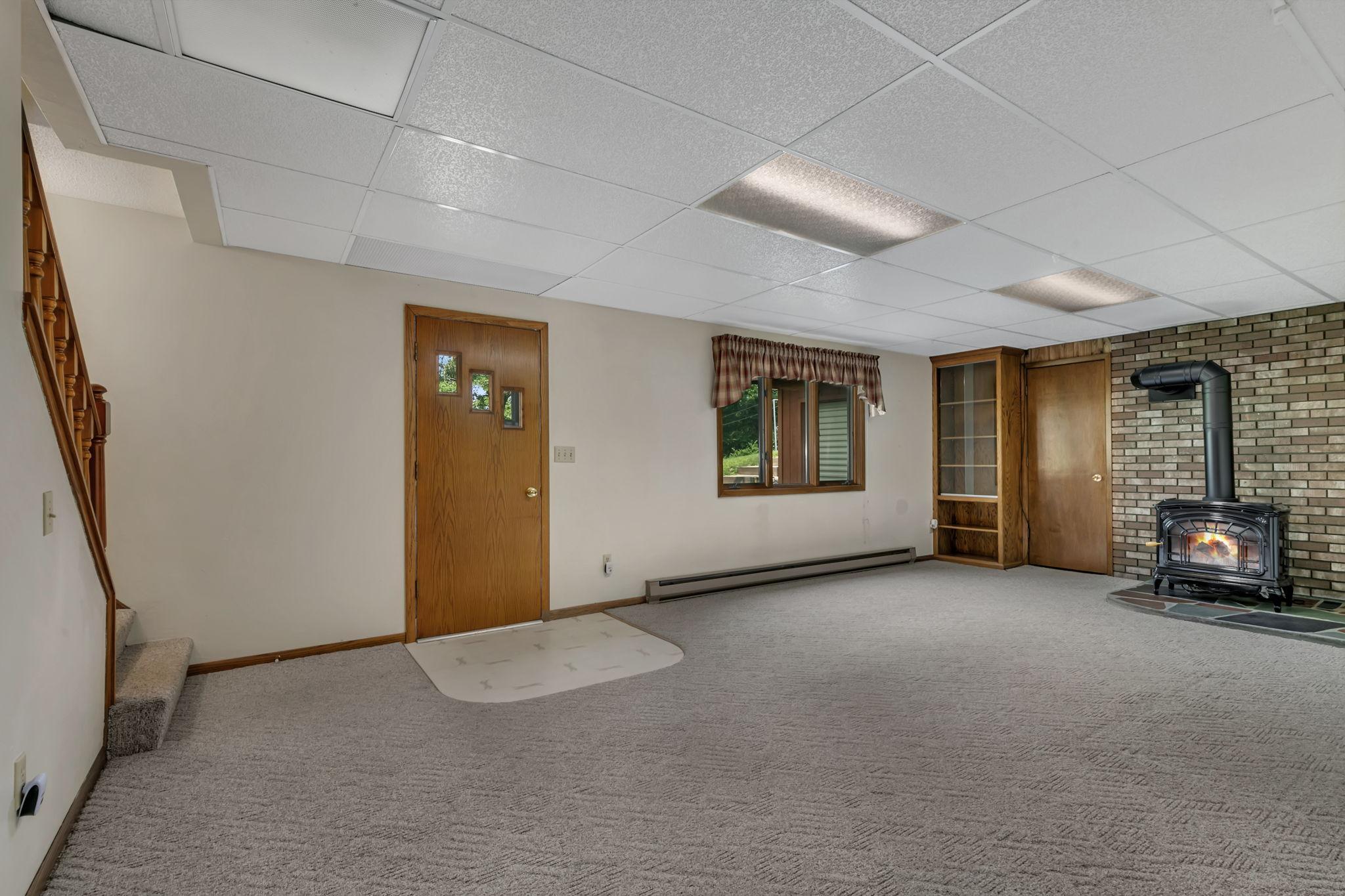This walkout rambler offers backyard access for the lower level family room. Access the huge cellar/cold storage room via the door by the fireplace