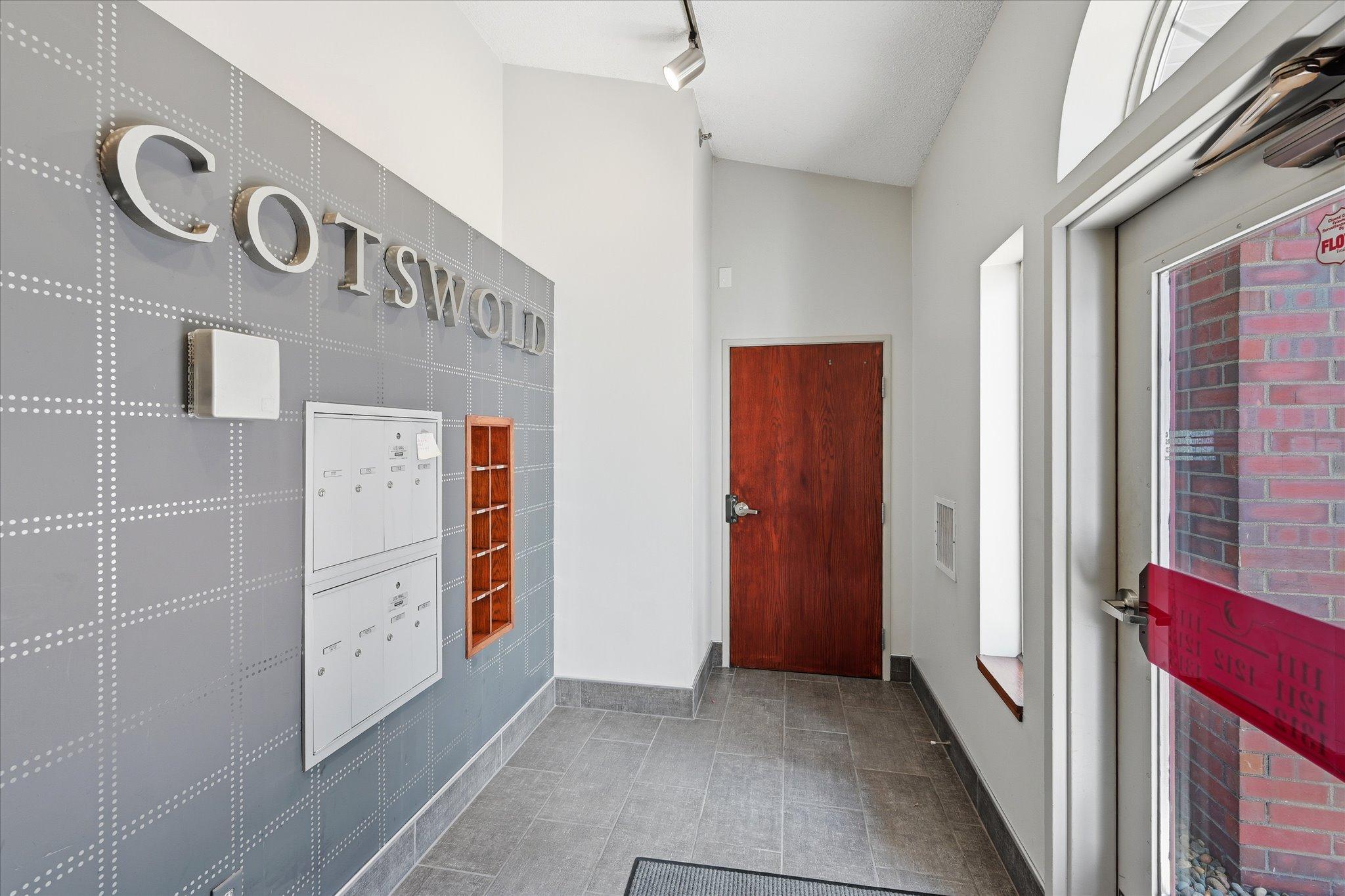 Foyer with mail, through that door is the secure door to access the condo and to the left is the short flight of stairs to garage.