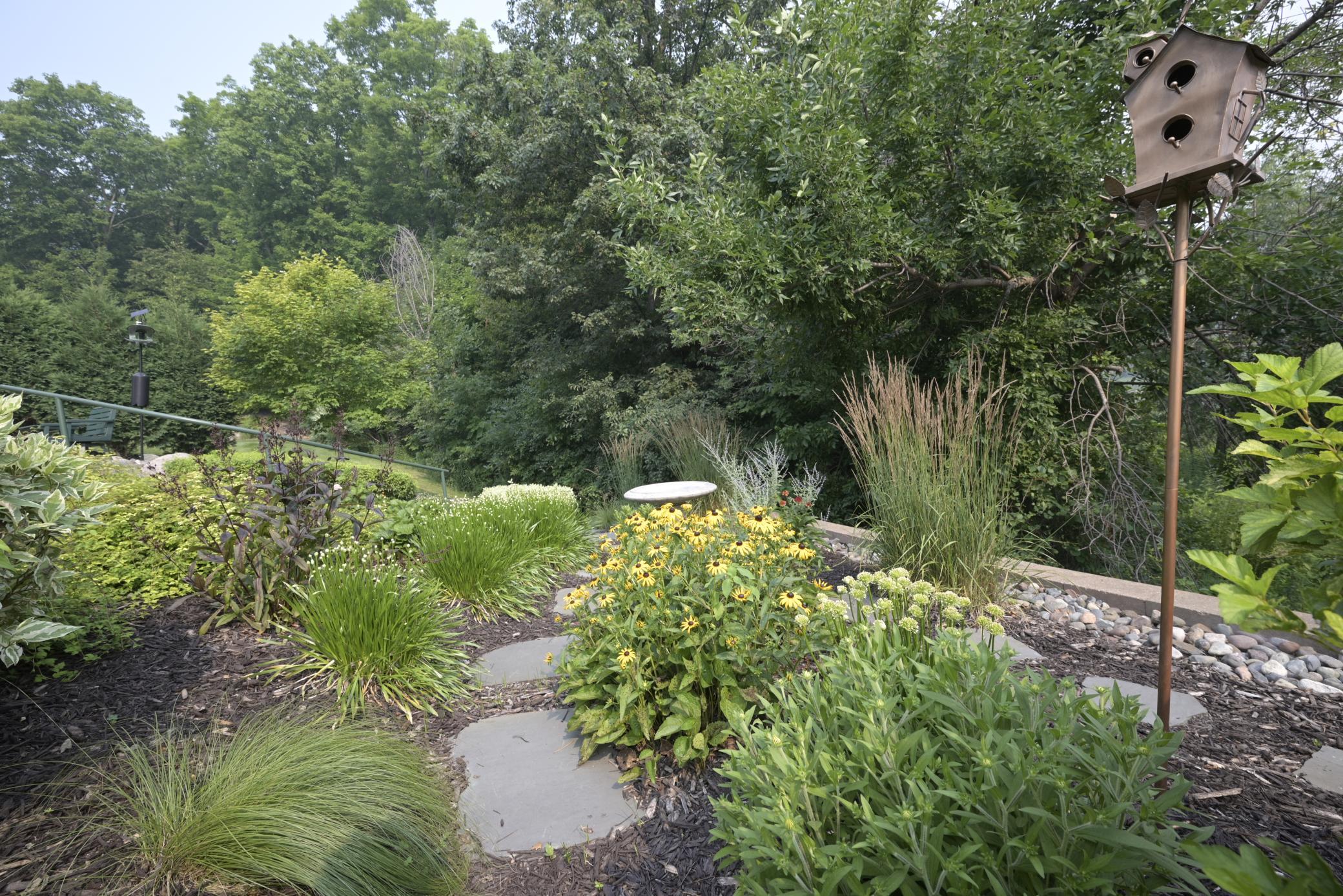 Steps with a railng take you to the lower level of landscaping