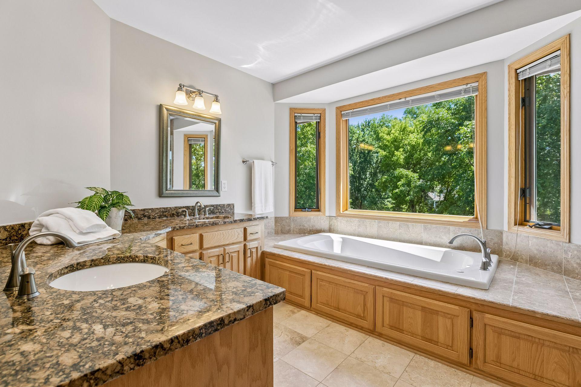 Primary full bath with double vanity and large jetted tub.