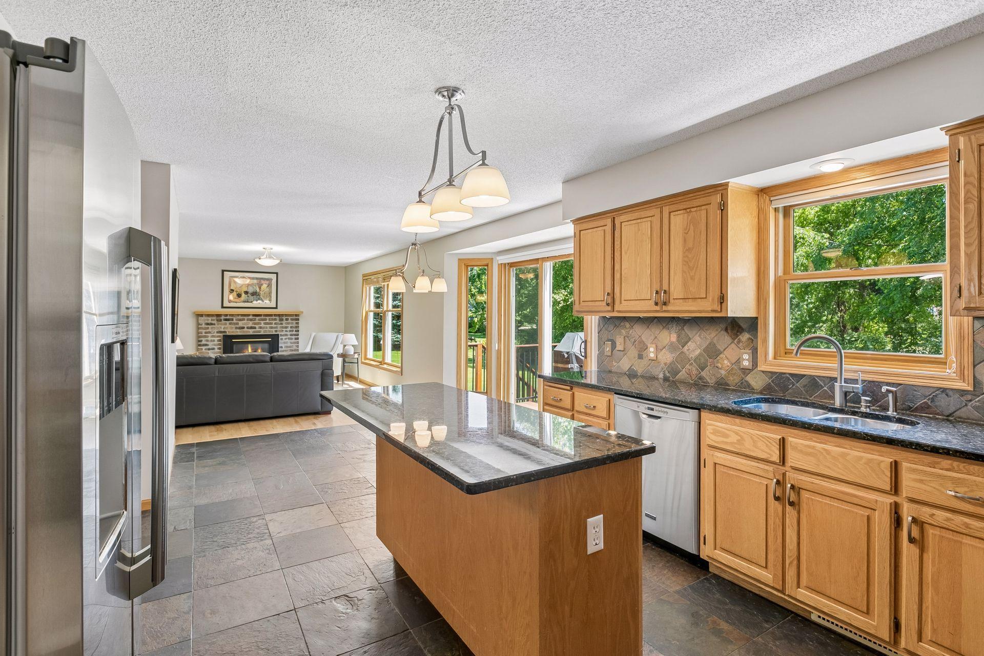 View of kitchen, looking into informal dining area and main living room.