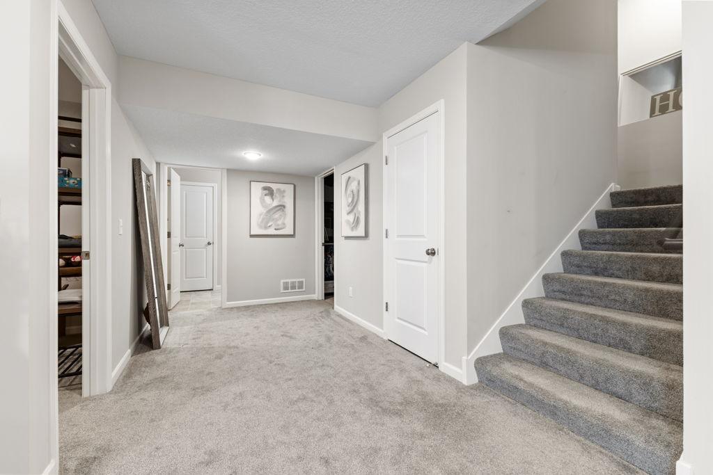 There is a flex room (open door to the left). Workout space, storage space, anything really. The closed door next to stairs is MORE under stair storage. The open door past that is the mechanical room and the bathroom is straight ahead.