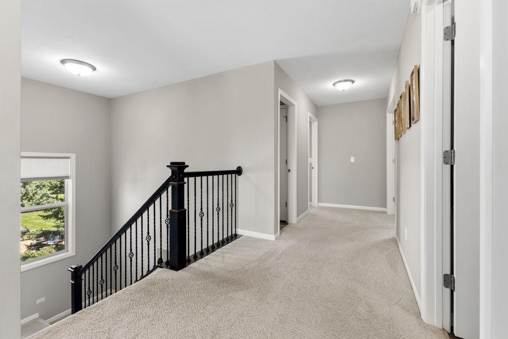 Landing space between the two west facing bedrooms. The laundry room is the first open door to the right in this photo. The full bathroom is the first open door to the left of this photo. The other two bedrooms are at the end of the hall.