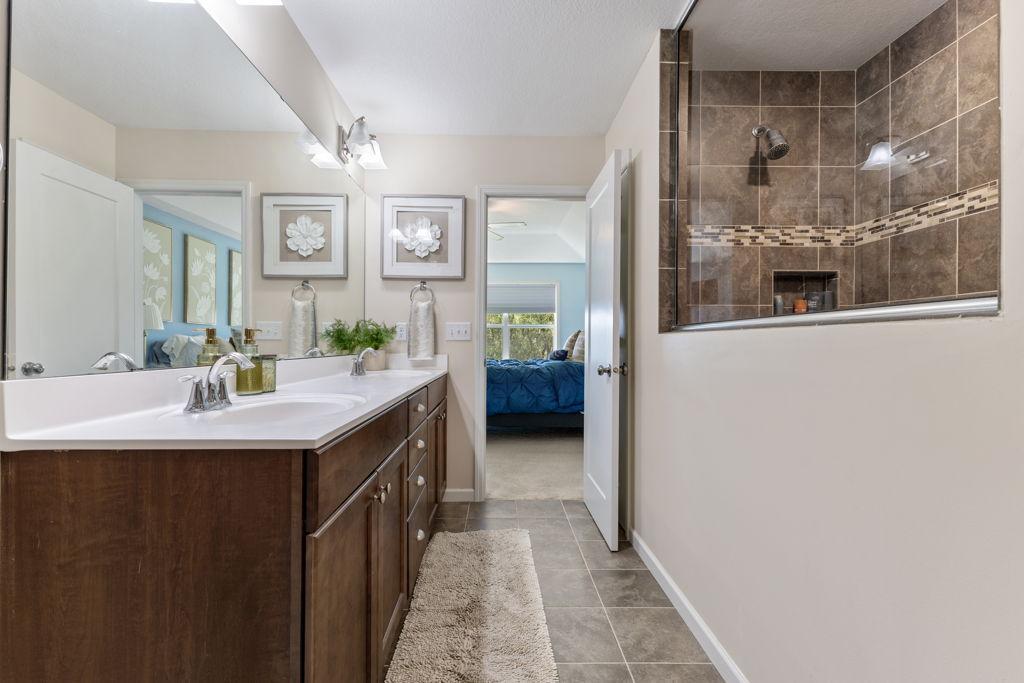 Here you have the primary bathroom with a shower that doesn't stop. Double vanity with storage there as well as a closet behind the door.