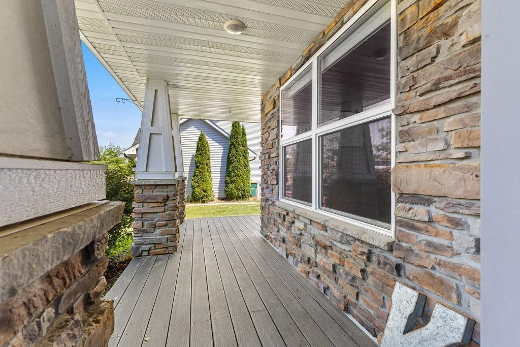A large front porch with a small wrap-around. Maintenance free decking and a stone front. Perfect for some front patio furniture. Such an inviting space...