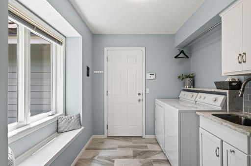 Convenient main-level laundry refreshed with quartz countertops, updated cabinetry, and beautiful tile finishes.