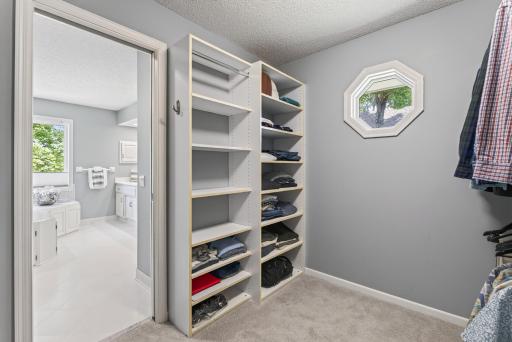 A spacious walk-in closet with custom built-ins keeps everything beautifully organized.