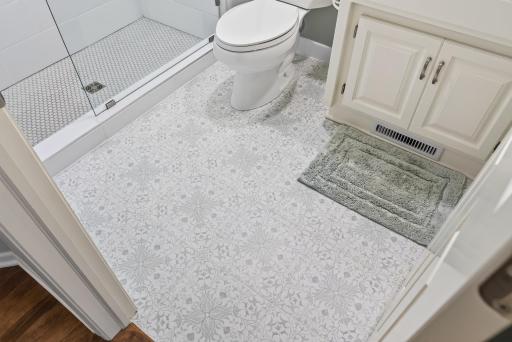 Beautiful hand-selected tile flooring from The Tile Shop adds warmth, texture, and timeless elegance to this stunning remodeled bath.